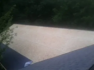 New OSB roof sheathing installed beside an existing shingle roof in Eastport